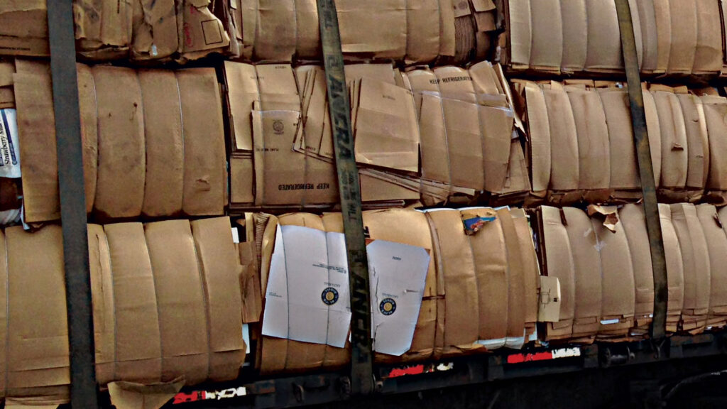 Stacked cardboard bales strapped onto truck bed