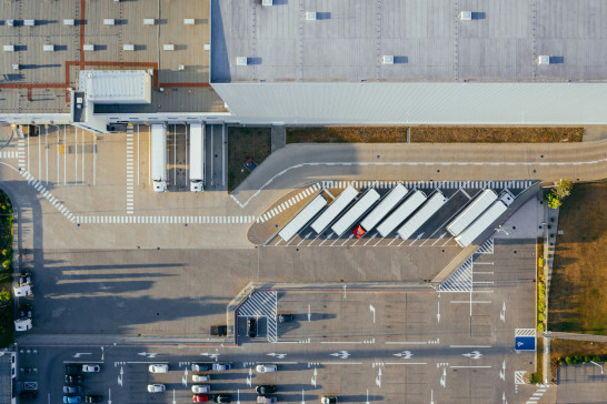 Birds-eye view of semi-trucks parked outside of building